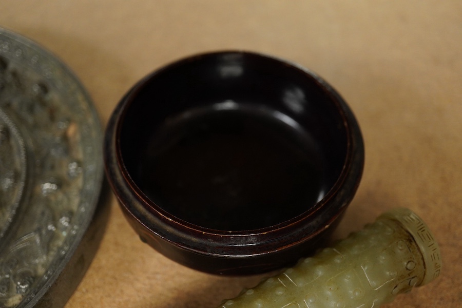 A Chinese silvered bronze mirror, a lacquer box and a jade cylindrical bead, largest 15cm diameter. Condition - fair to good